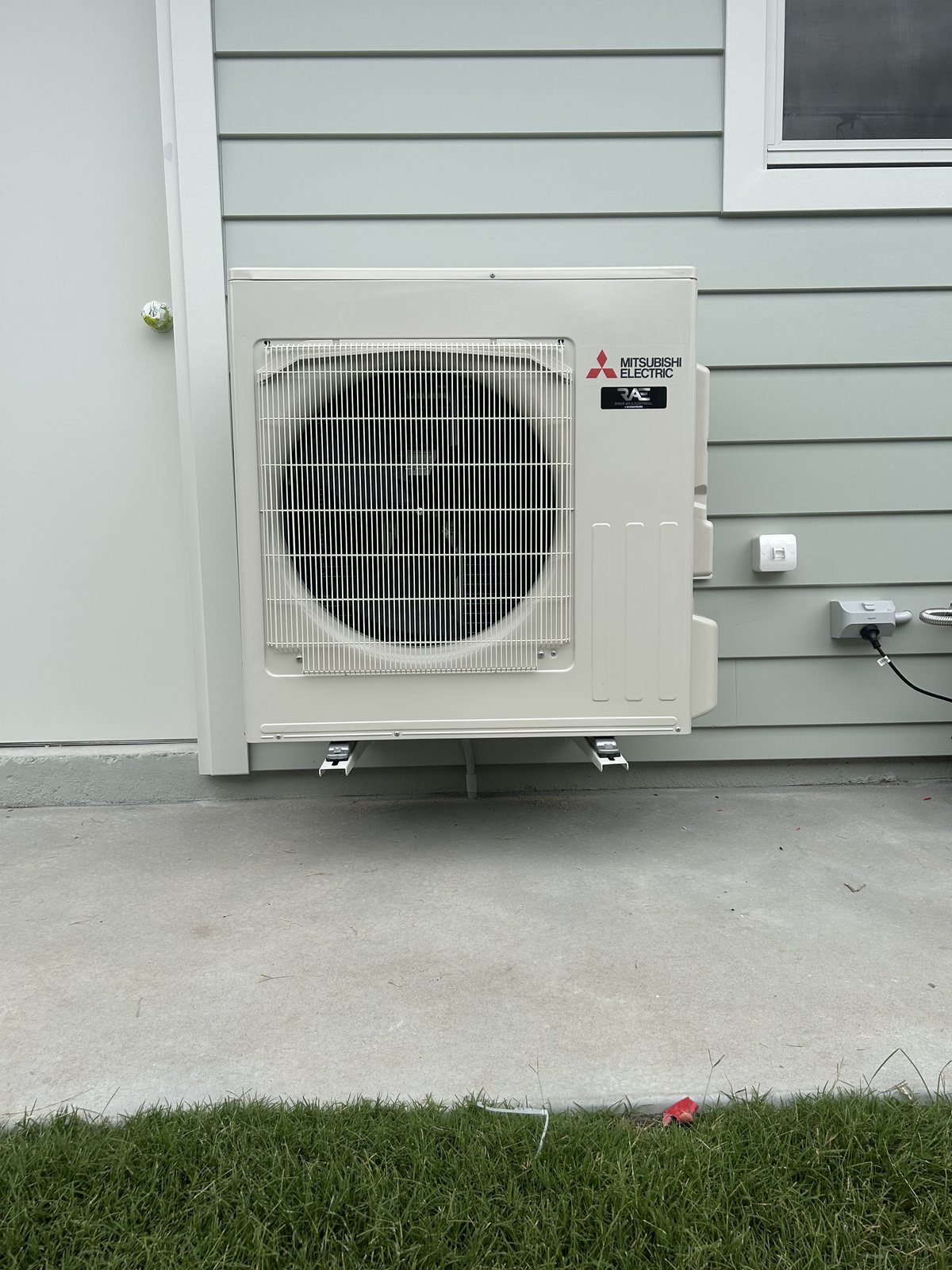 Mitsubishi Electric condenser installed by Ryder Air and Electrical, mounted on brackets at a Grafton home